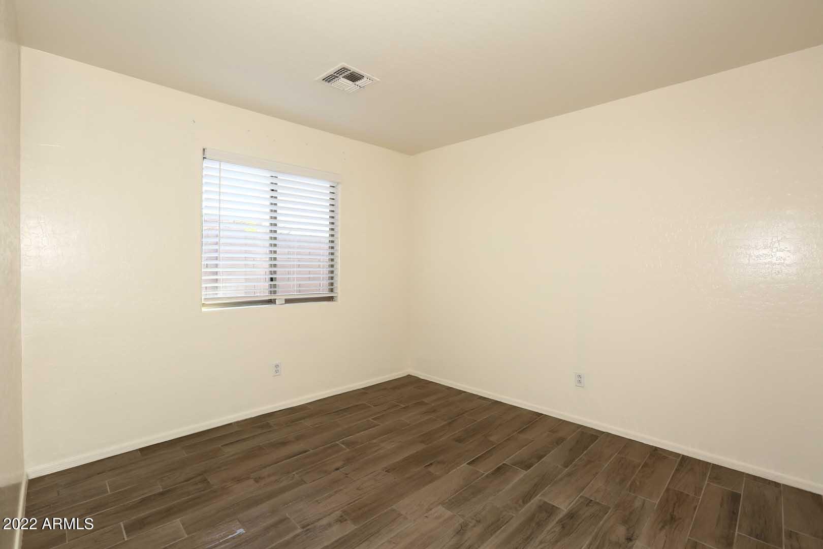 4319 West Carson Road Laveen, AZ 85339 - Photo 26 of 36 an empty room with wooden floor and windows