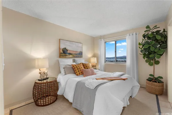 a bedroom with a bed and a potted plant