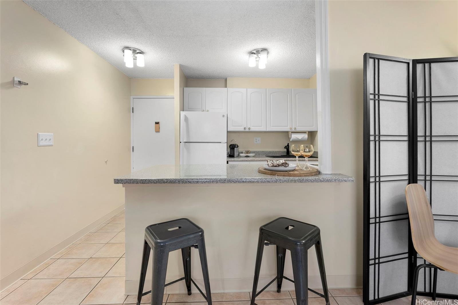 98-1038 Moanalua Road, Unit 1502 Aiea, HI 96701 - Photo 9 of 20 a kitchen with stainless steel appliances a refrigerator and cabinets