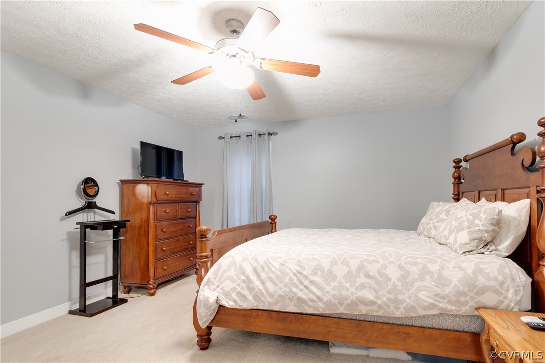 473 Winding Ridge Way Bumpass, VA 23024 - Photo 14 of 25 a bedroom with a bed and a chandelier