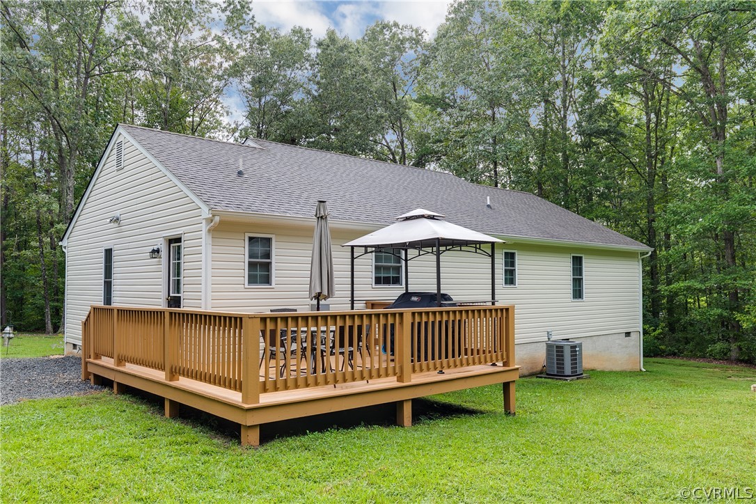 473 Winding Ridge Way Bumpass, VA 23024 - Photo 22 of 25 a view of a house with a yard and deck area under a large tree