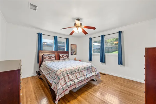 a bedroom with a beds chandelier and a window