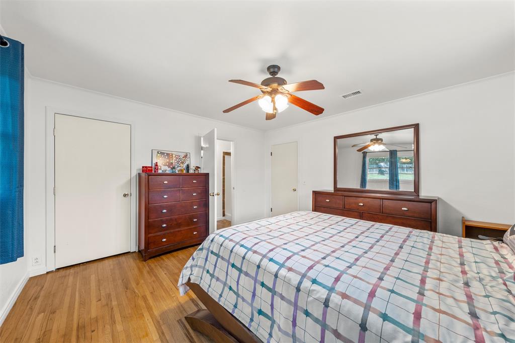 110 Butler Drive Valley Mills, TX 76689 - Photo 16 of 26 a bedroom with a bed and a chandelier