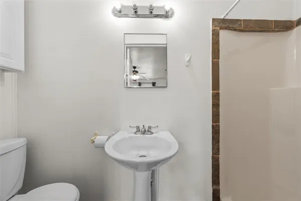 a bathroom with a toilet sink and mirror