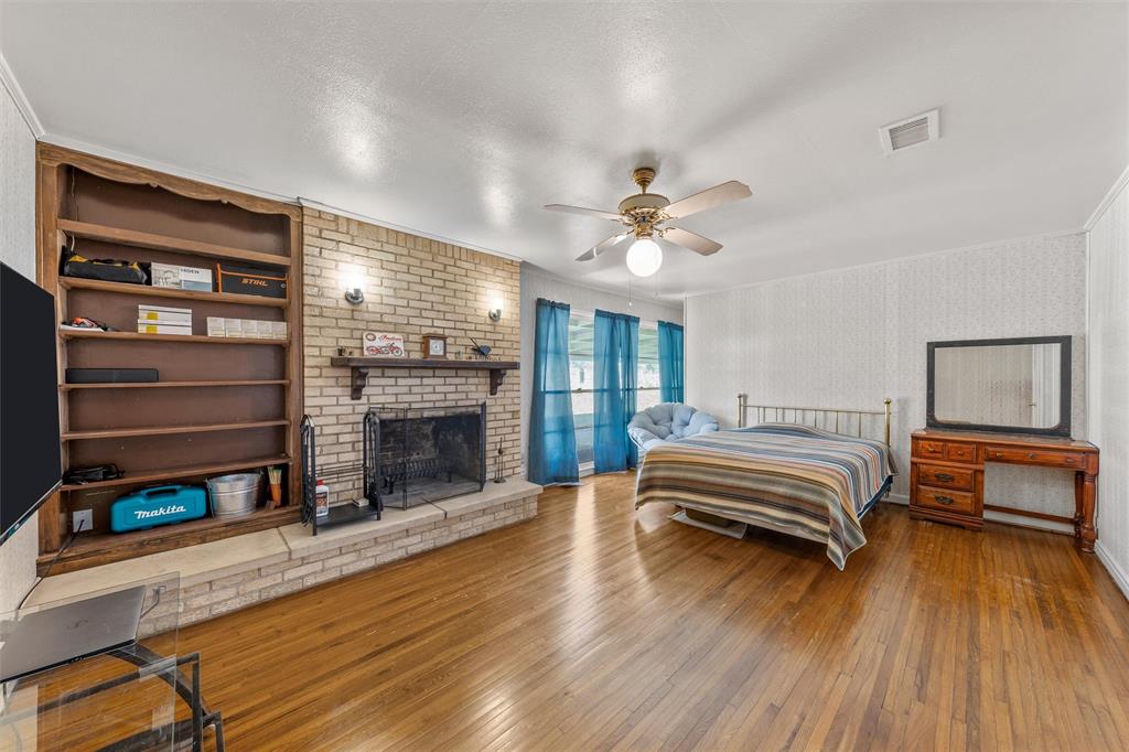 110 Butler Drive Valley Mills, TX 76689 - Photo 18 of 26 a spacious bedroom with a bed and a chandelier