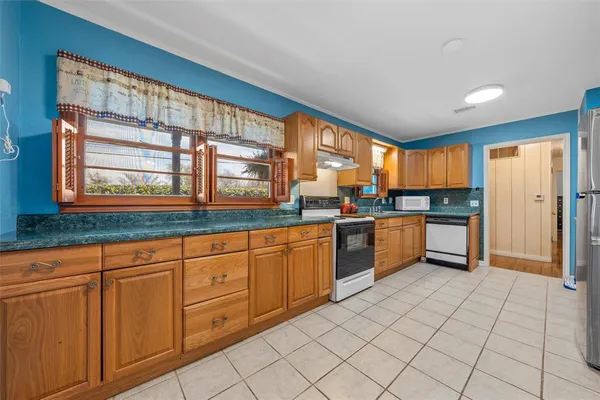 a kitchen with stainless steel appliances granite countertop a stove a sink and a refrigerator