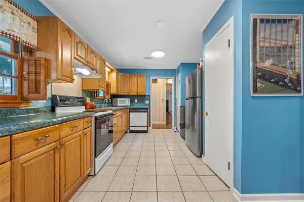 a kitchen with stainless steel appliances granite countertop a refrigerator and a stove top oven