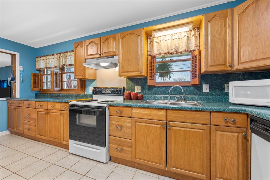 110 Butler Drive Valley Mills, TX 76689 - Photo 8 of 26 a kitchen with granite countertop a stove sink and cabinets