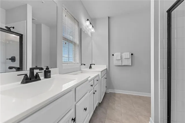 a bathroom with double vanity and a mirror