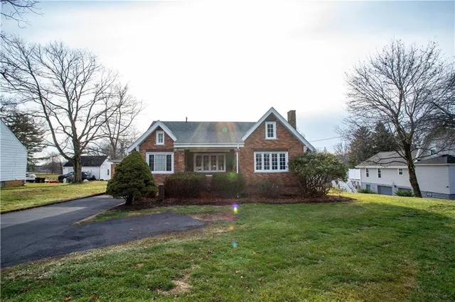 a front view of a house with a yard and trees