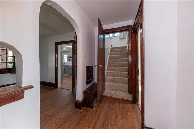 a view of a hallway with wooden floor and staircase