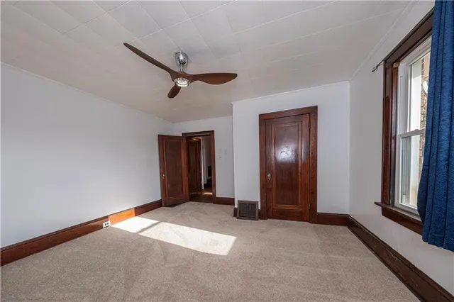 a view of empty room with wooden floor and windows