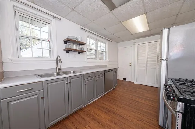 a kitchen with a sink cabinets stainless steel appliances and a window