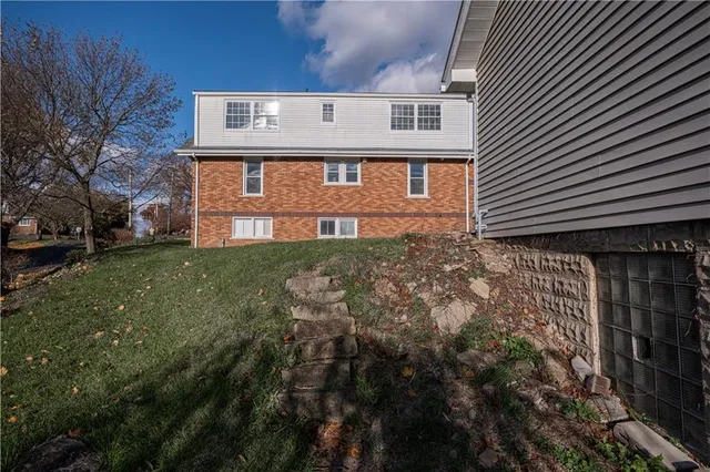 a front view of a house with yard and green space