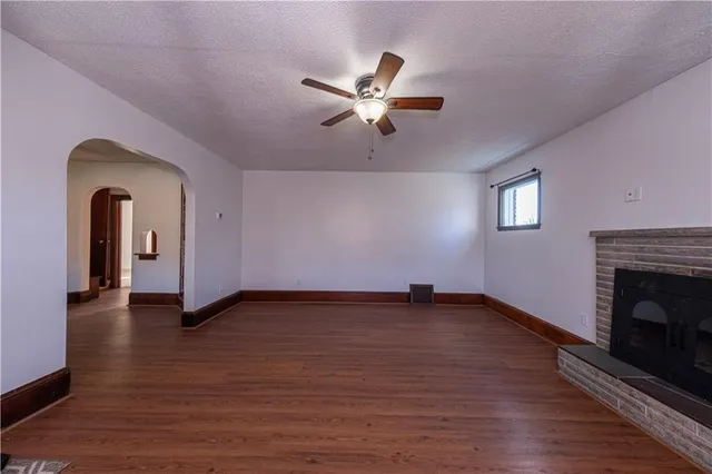 a view of empty room with wooden floor and fireplace