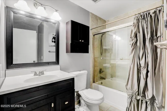 a bathroom with a sink a toilet a mirror and shower