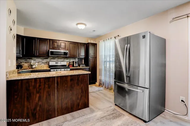 a kitchen with stainless steel appliances a refrigerator and a stove top oven