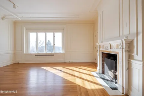 a view of an empty room with window and fire place