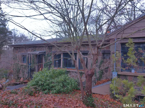 a view of a brick house with large windows and a small yard