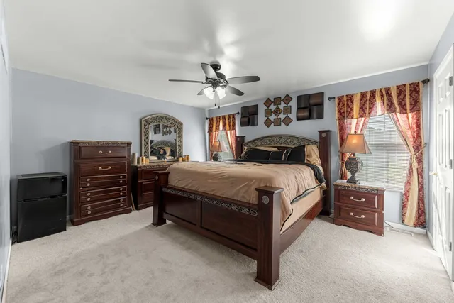 a spacious bedroom with a bed and a chandelier