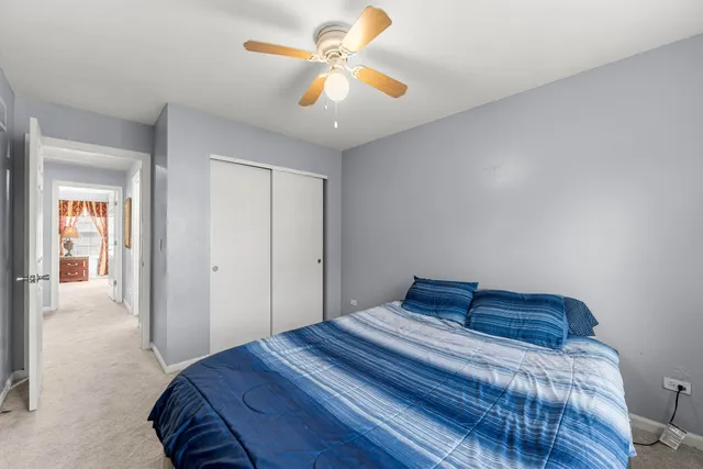 a bedroom with a bed and a ceiling fan