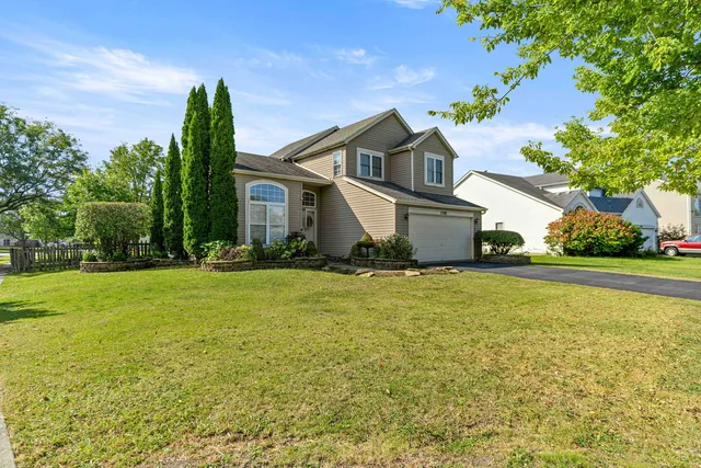 a front view of house with yard and trees
