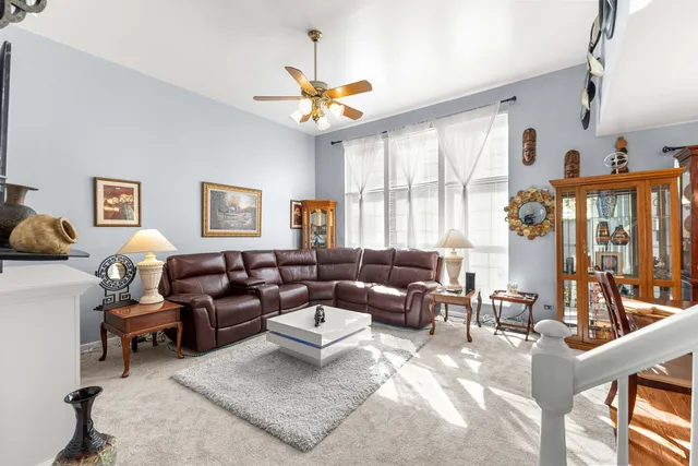 a living room with furniture a chandelier and a large window