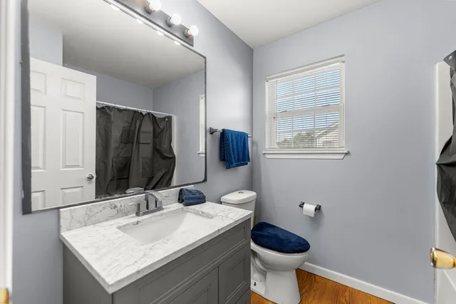 a bathroom with a granite countertop toilet sink and mirror