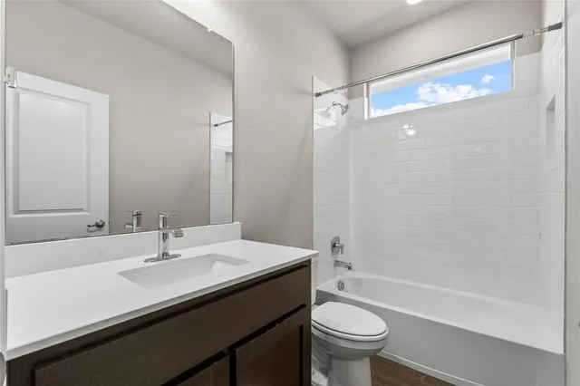 a bathroom with a sink a toilet a mirror and a glass door shower