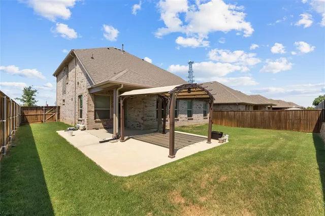 a view of a house with backyard and sitting area