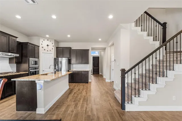 a view of kitchen with sink microwave and refrigerator