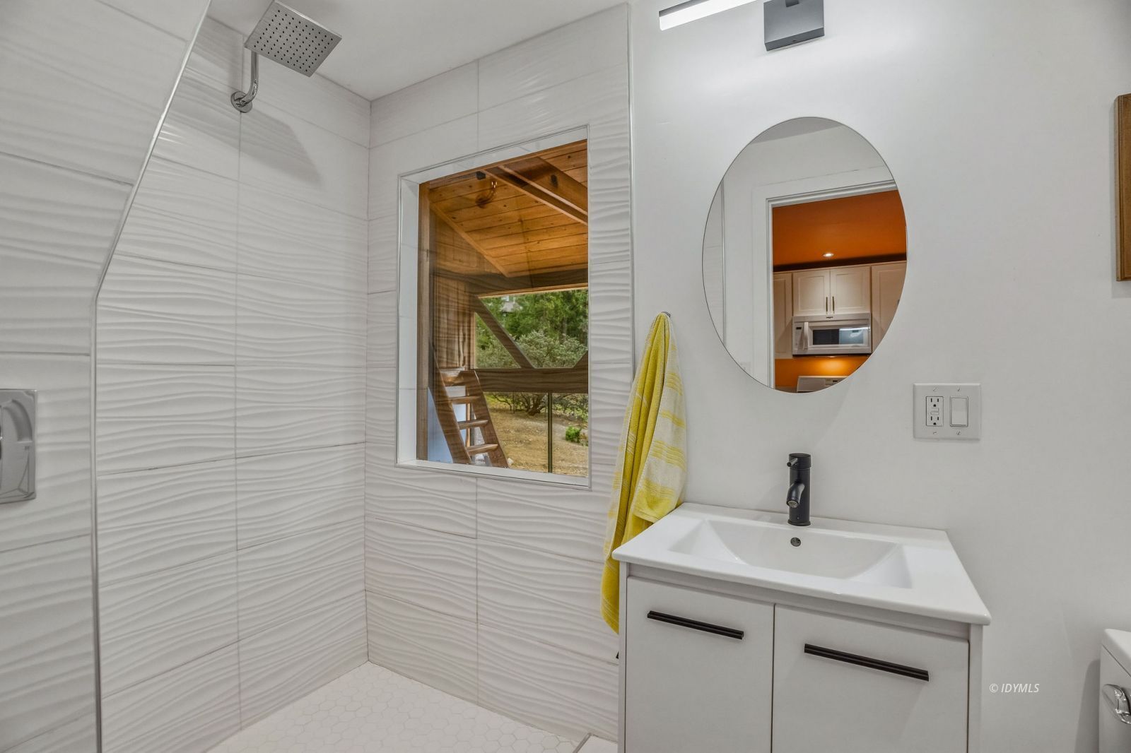 25106 Rim Rock Road Idyllwild, CA 92549 - Photo 42 of 71 a bathroom with a sink a mirror a vanity and a window
