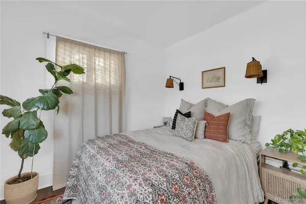 a bedroom with a bed potted plant and a window