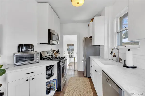 a kitchen with stainless steel appliances a sink stove and refrigerator