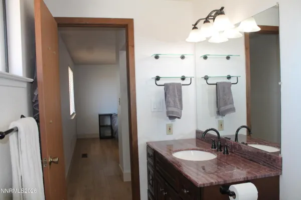 a bathroom with a granite countertop sink a mirror and shower