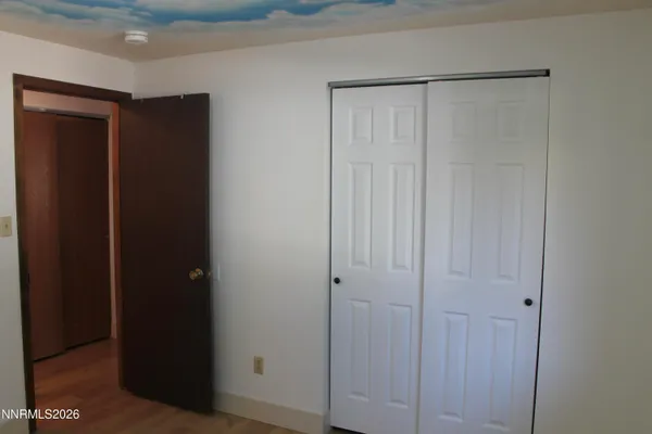 a view of a closet with wooden floor