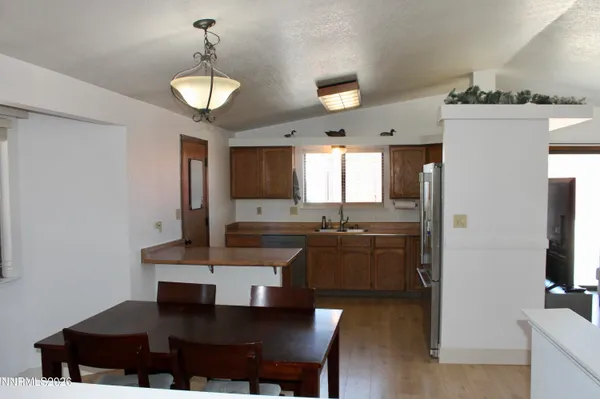 a kitchen with a dining table chairs and refrigerator