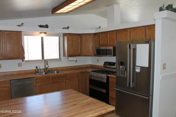 a kitchen with granite countertop stainless steel appliances and wooden cabinets
