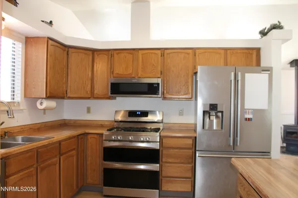 a kitchen with stainless steel appliances granite countertop a refrigerator stove and microwave
