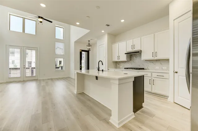 a kitchen with stainless steel appliances sink refrigerator and cabinets
