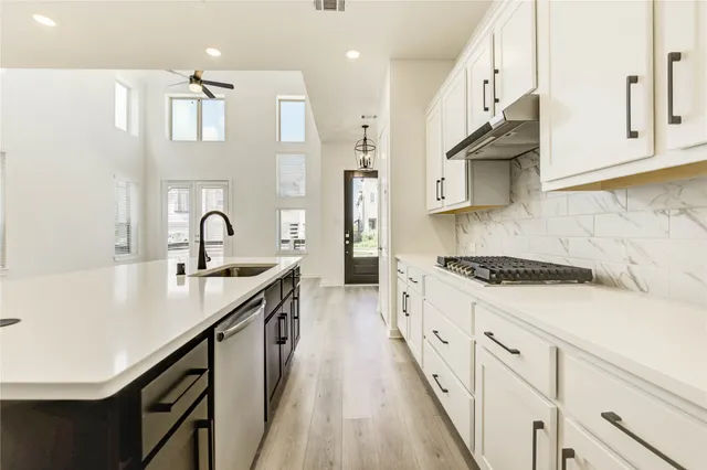 a kitchen with stainless steel appliances a sink stove and cabinets