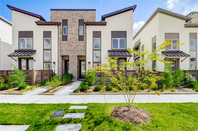 a front view of a house with a yard and potted plants