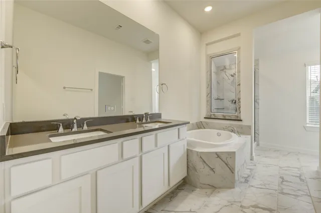 a spacious bathroom with a granite countertop sink and a mirror