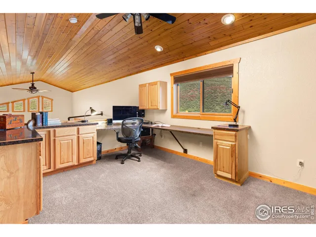 a view of a workspace with furniture and a window