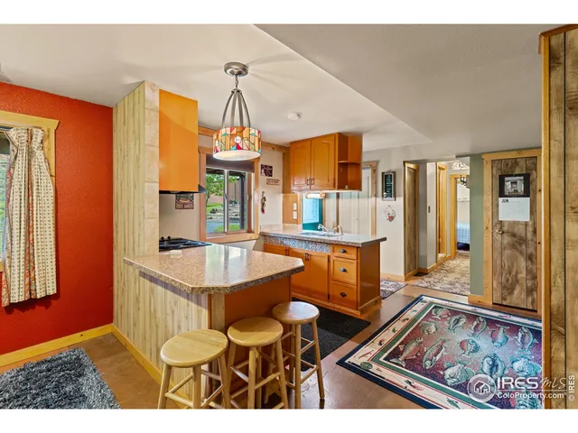 a living room with stainless steel appliances kitchen island granite countertop furniture and a rug