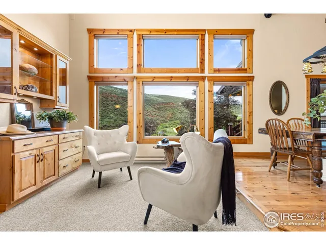 a living room with furniture a fireplace and a large window