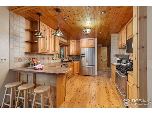 a kitchen view with stainless steel appliances kitchen island granite countertop a sink and cabinets