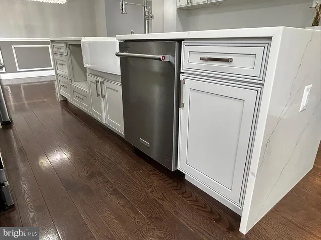 a kitchen with a refrigerator and wooden floor