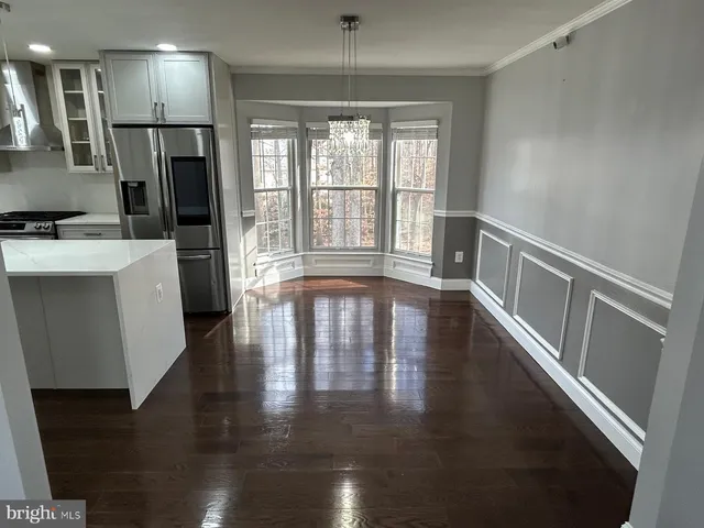 a view of entryway with kitchen and wooden floor