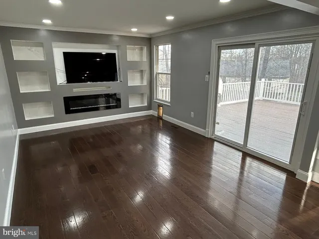 a living room with a flat screen tv and a floor to ceiling window